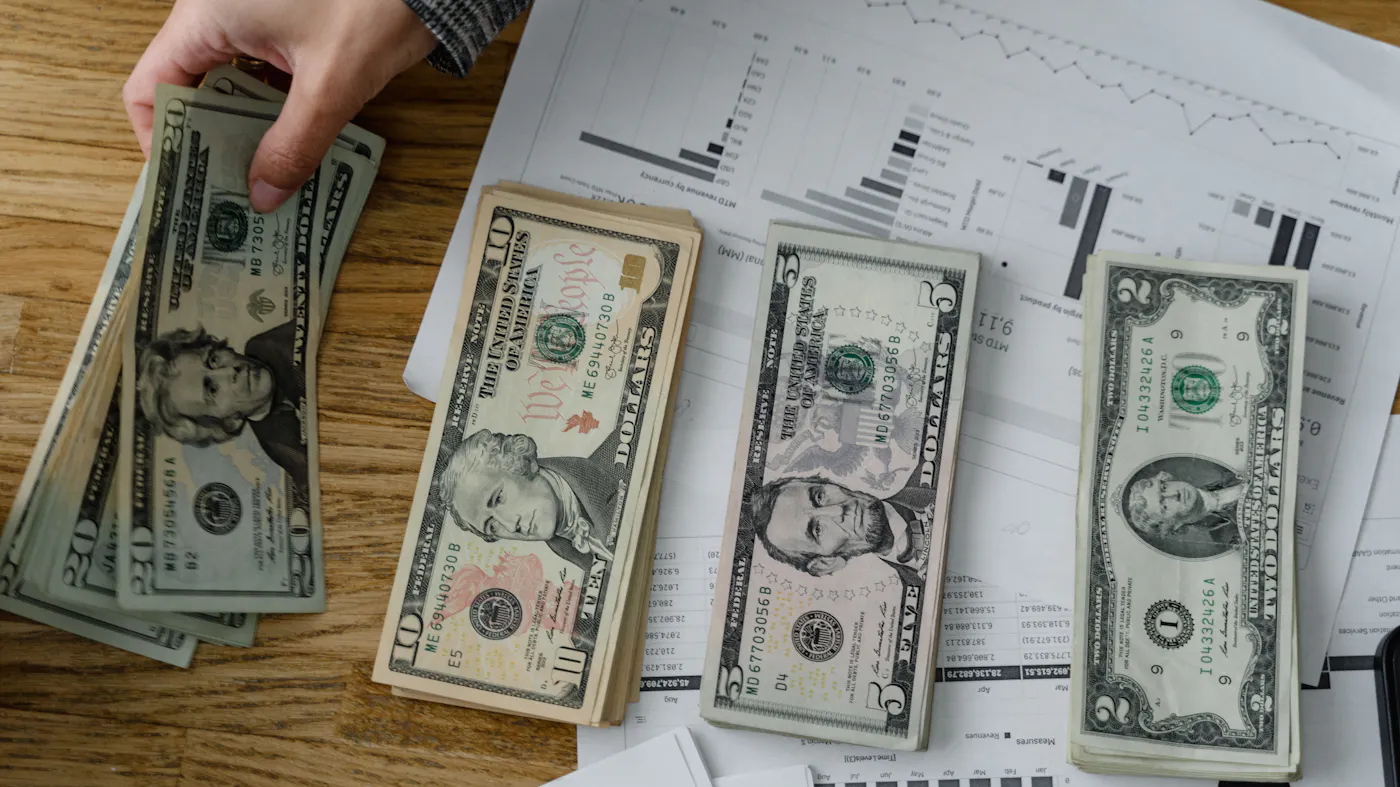 A person counting cash on a table — the literal cash in an Austin cash offer for a home