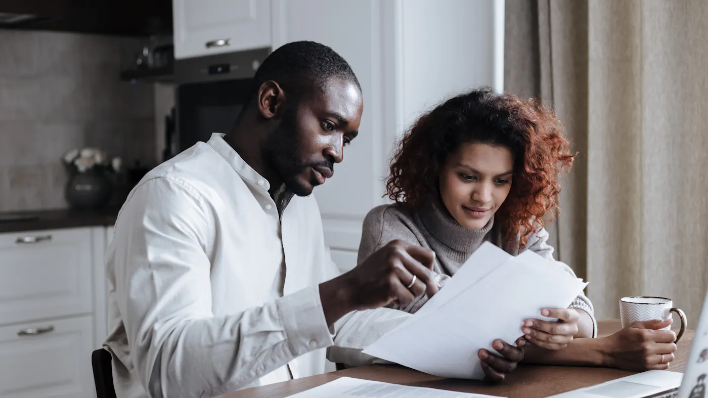 Heirs reviewing estate documents at a kitchen table while deciding whether to sell a house in probate