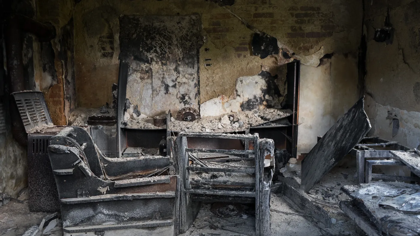 The charred interior of a fire-damaged home — the condition a cash buyer purchases as-is