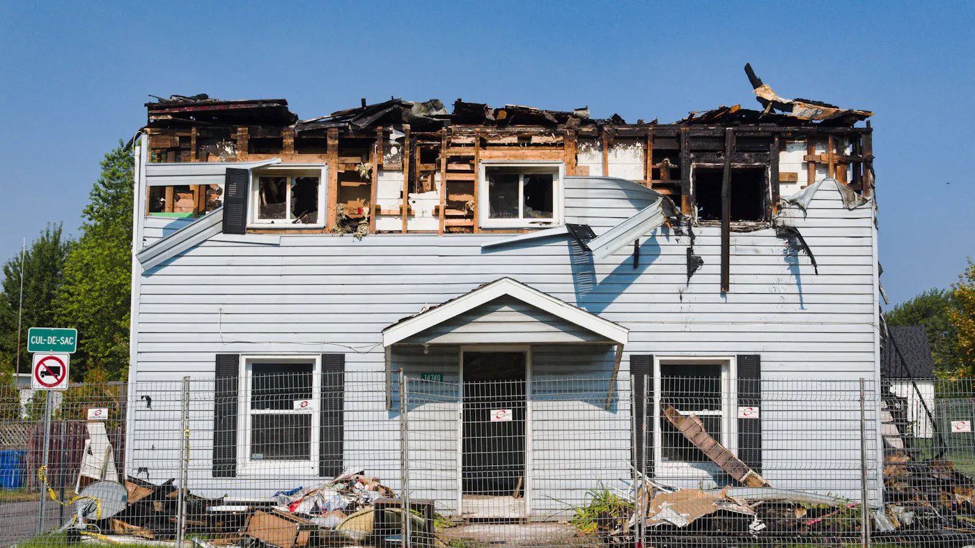 A fire-damaged house exterior awaiting a professional damage assessment before sale